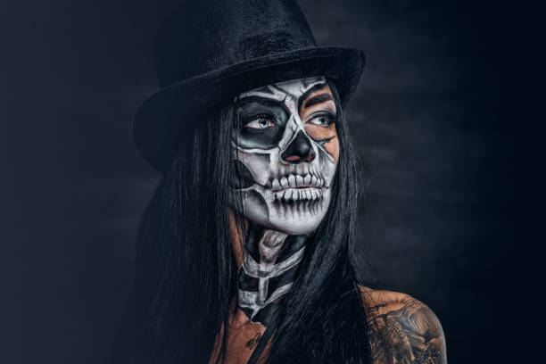 istock A woman with skull make up in top hat on Halloween. 938976692
