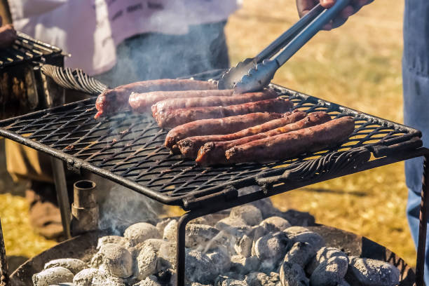 Sausages on a bbq grill Cook out BBQ sausage on an open coal fire grill south african braai stock pictures, royalty-free photos & images