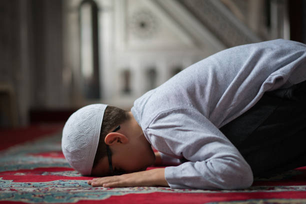 muslim boy praying in mosque - islam praying mosque ramadan imagens e fotografias de stock