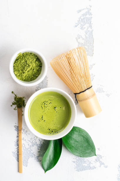istock Green matcha tea drink and tea accessories on white background 938977496