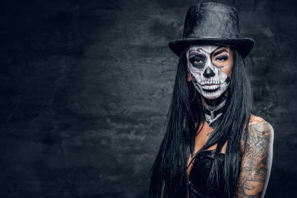 istock A woman with skull make up in top hat on Halloween. 938977644