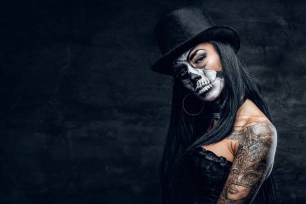 istock A girl in stylish top hat with skull make up. 938980964