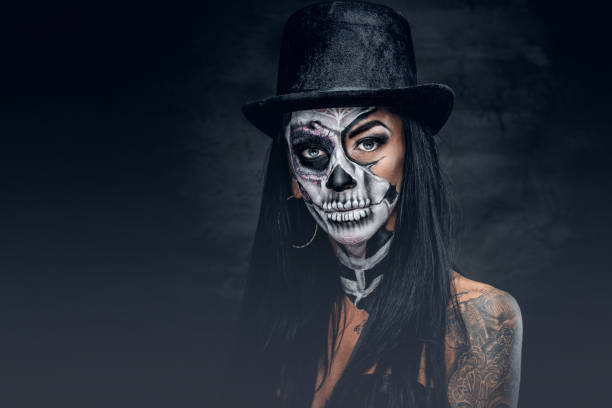 istock A woman with skull make up in top hat on Halloween. 938982092
