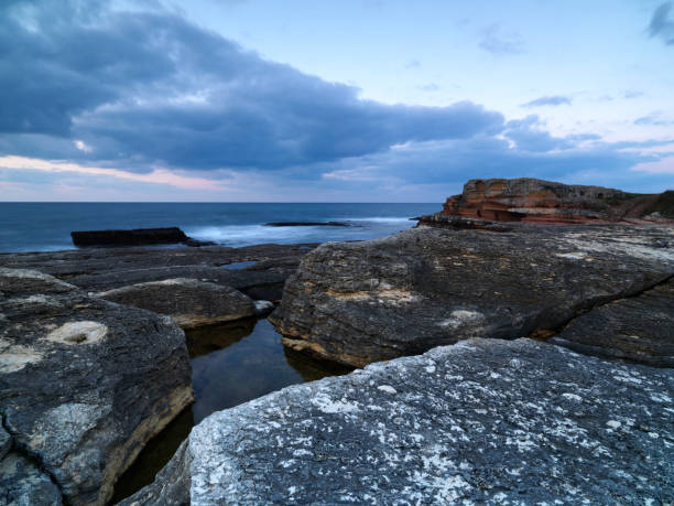 istock Seascape with bright sunset over the rocks 938982460