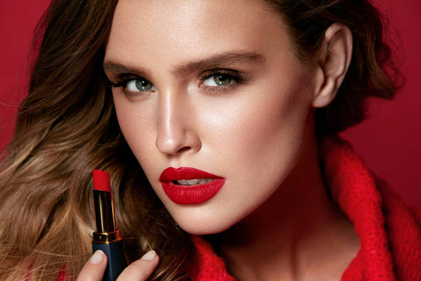 istock Red Lips. Beautiful Woman With Beauty Makeup Holding Lipstick. 938987316