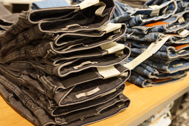 istock Row of hanged blue jeans in a shop 938989604