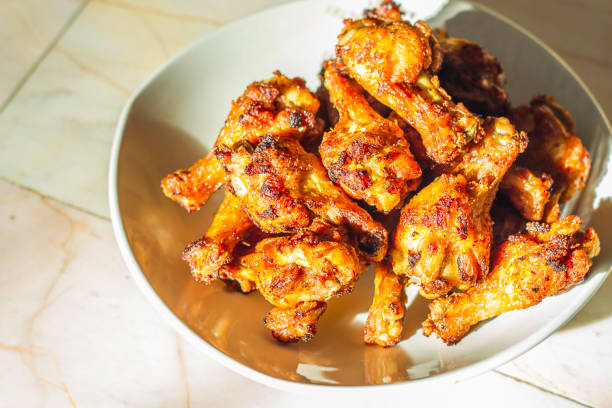 istock Grilled chicken drumsticks fried crispy marinated with honey is served in a flat white dish on a white background 938990260
