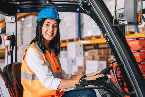 istock Young woman driving a forklift at warehouse 938990444