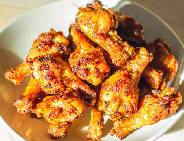 istock Grilled chicken drumsticks fried crispy marinated with honey is served in a flat white dish on a white background 938990530