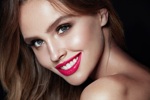 Beauty Makeup. Woman With Beautiful Face And Pink Lips. Close Up Of Beautiful Young Elegant Female Model With Glamorous Sexy Makeup, Soft Smooth Skin And Plump Full Pink Lips. High Quality Image.