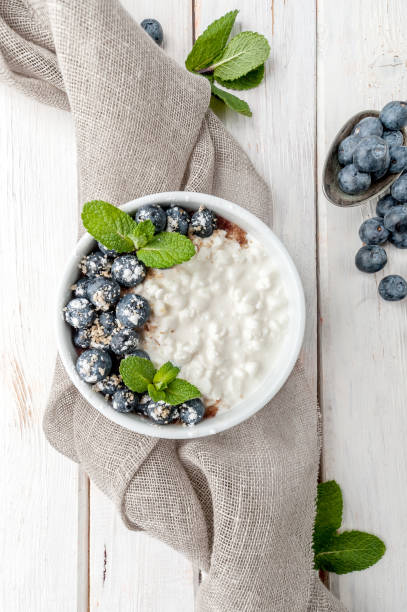 Cottage cheese with fresh blueberries and mint leaves on a white board background. Cottage cheese with fresh blueberries and mint leaves on a white board background. cottage cheese photos stock pictures, royalty-free photos & images