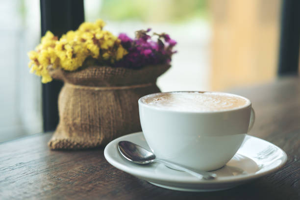 une blanche tasse de café au lait chaud café avec des fleurs dans un vase sur une table en bois vintage - flower pot vase purple decor photos et images de collection