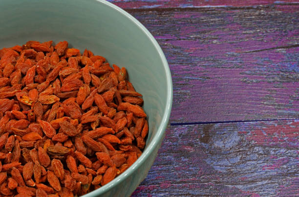 bowl of dry goji berries on wooden background - antioxidant medicine closed close to imagens e fotografias de stock