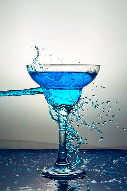 glass with blue champagne or cocktail. levitation - action alcohol alcoholism bar imagens e fotografias de stock