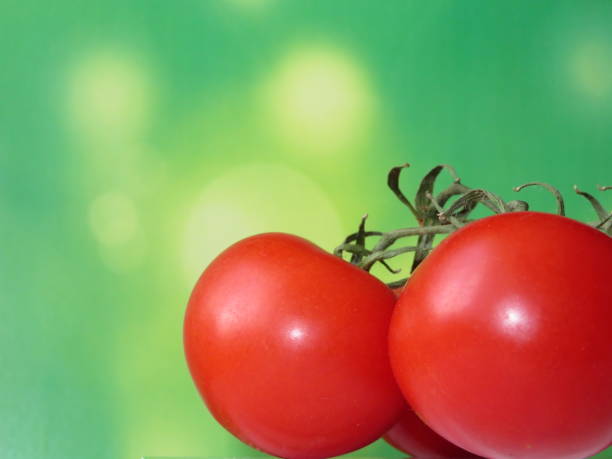 istock Ripe cherry tomatoes closeup on green background 939005972