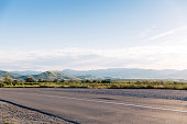 Empty asphalt road with blue summer sky and hills on background. Crimea, Koktebel.