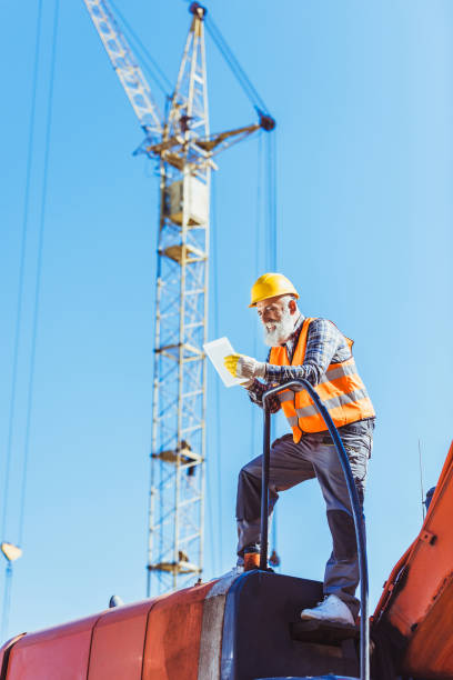 pracownik budowlany za pomocą tabletu cyfrowego - crane mobile crane derrick crane construction vehicle zdjęcia i obrazy z banku zdjęć