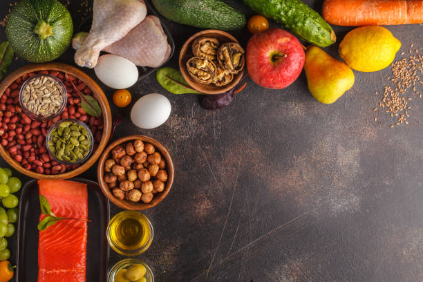 istock Paleo diet concept. Balanced food frame background. Copy space, dark background. Fresh raw vegetables, fruits, meat, fish, top view. 939017414