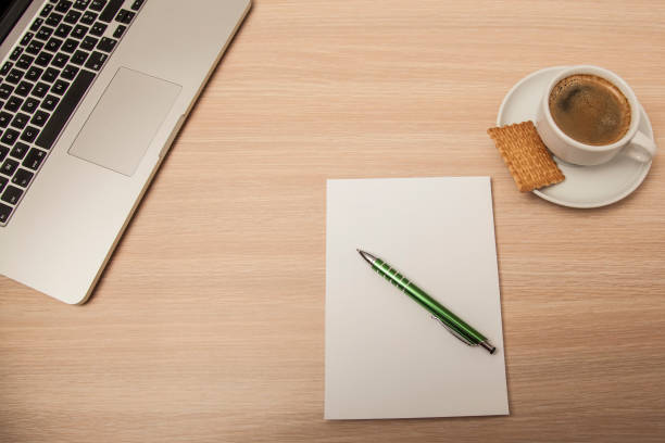 istock wooden desk with a notebook, top view 939018770