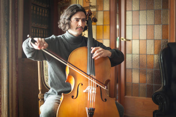 Handsome artist playing cello with serious face