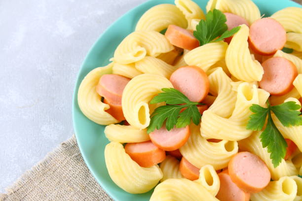 istock Pasta Cavatappi or Cellentani with sausages on a gray table. 939019878