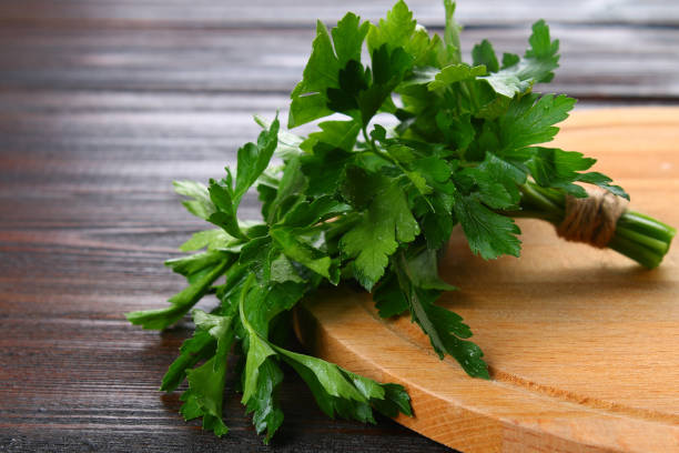 istock Fresh green parsley on the wooden table, selective focus. 939019906