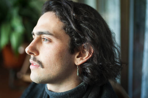 istock Long haired young man with moustache and ear ring portrait 939022560