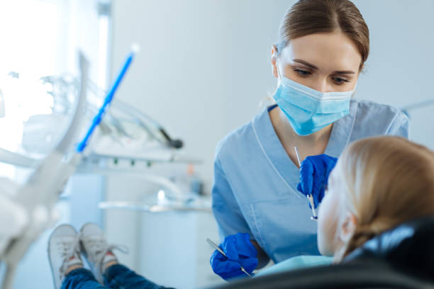 istock Pleasant female dentist checking oral cavity with special mirror 939023222