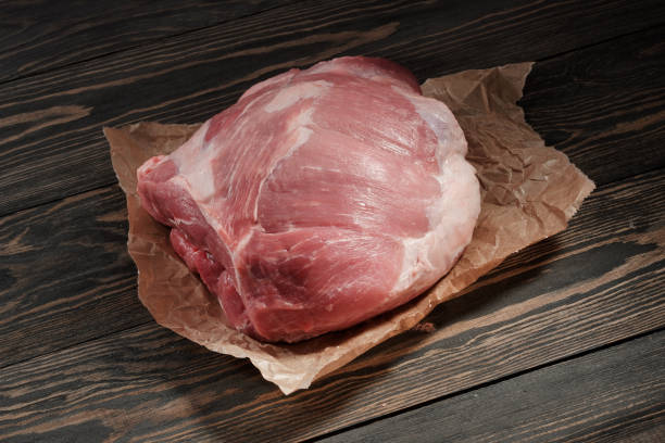 une épaule de porc cru de morceau. filet de porc sur papier sur un fond sombre - pork tenderloin dinner barbecue photos et images de collection