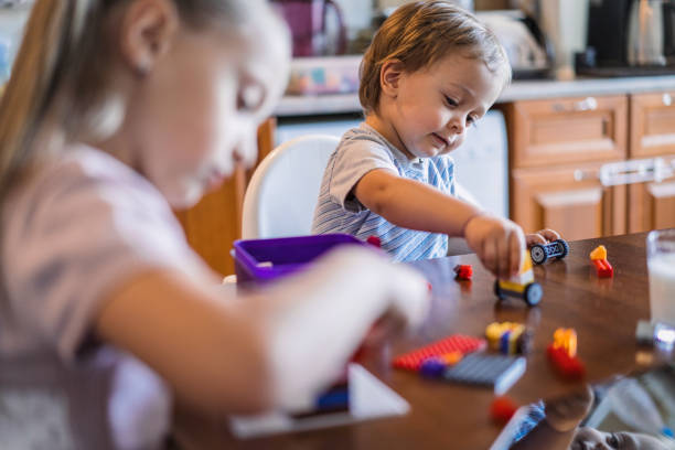 istock Kids playing with colorful bricks at dining table 939026642
