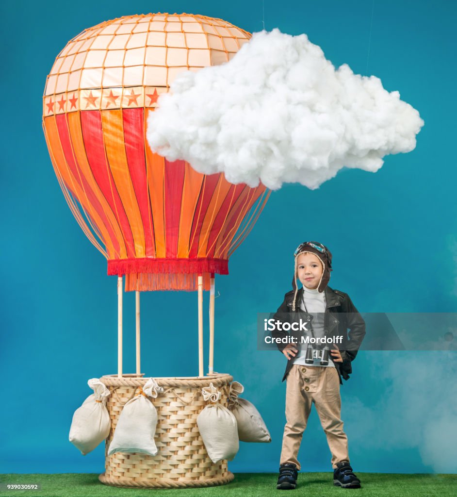 Preschool Boy Aeronaut The happy boy dressed as vintage aeronauts clothes standing next to a hot-air balloon Hot Air Balloon Stock Photo