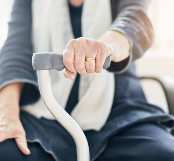 istock Seated old woman leaning on walking stick 939031422