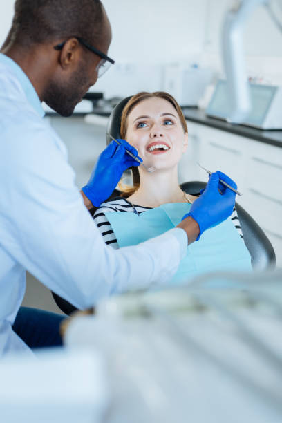 istock Charming woman smiling at dentist while he examining her 939034444