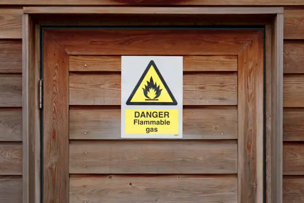 Danger flammable gas oil leak warning caution sign on door for safety of public and people