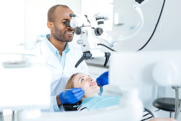 istock Pleasant dentist checking for cracks in patients teeth 939036346