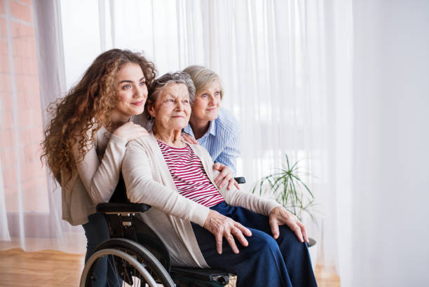 Teenage girl with mother and grandmother in wheelchiar at home. A teenage girl with her mother and grandmother in wheelchair at home. Family and generations concept. teenage girl with grandmother stock pictures, royalty-free photos & images