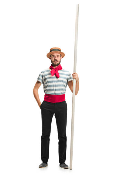 Caucasian man in traditional gondolier costume and hat Caucasian funny bearded man in traditional gondolier costume and hat with paddle standing and posing at studio isolated on white background. Serious young man. Human emotions, facial expression concept gondolier stock pictures, royalty-free photos & images