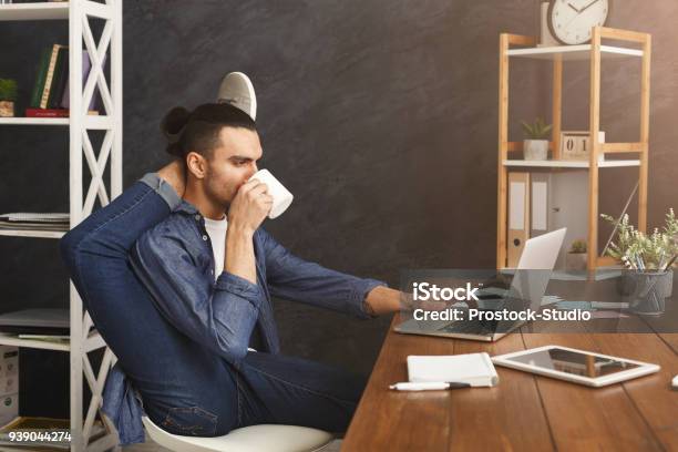 Flexible Man Practicing Yoga At Workplace Stock Photo - Download Image Now - Flexibility, Office, Yoga