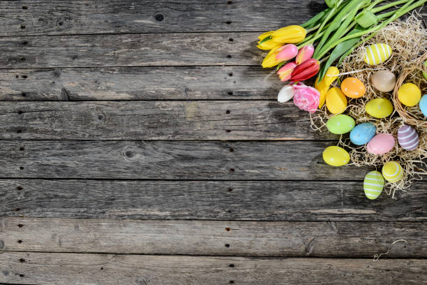 istock above top view of multi colored painted easter eggs with springtime tulip bouquet flowers on a old wood plank 939046326