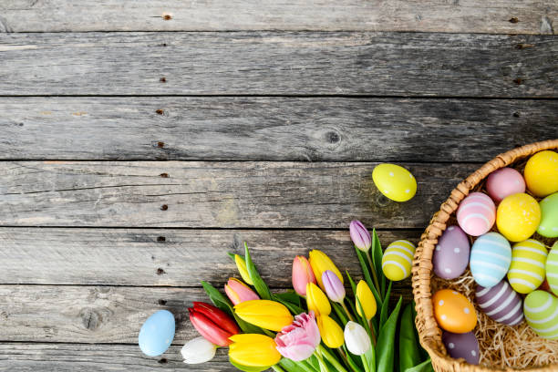 istock above top view of multi colored painted easter eggs with springtime tulip bouquet flowers on a old wood plank 939046338