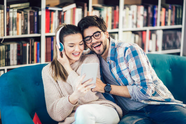 istock Young couple in indoor cafe using digital tablet 939056912