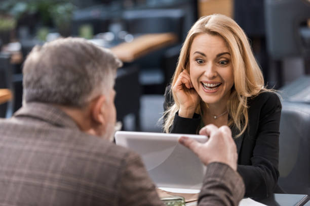 istock partial view of business people using tablet on meeting in cafe 939057760