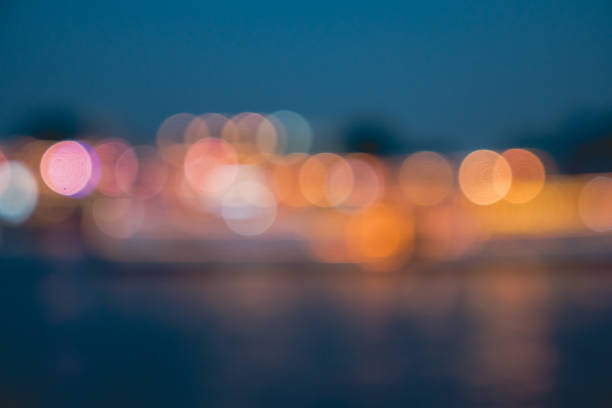 istock Blurred city lights with bokeh effect reflected on water 939061158
