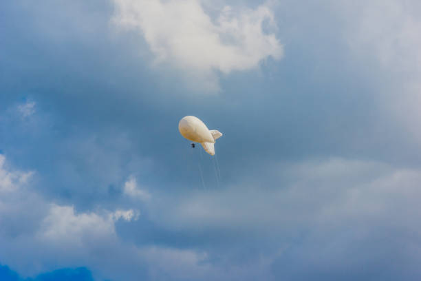 военный аэростат в красивом небе с драматическими облаками - spy balloon стоковые фото и изображения