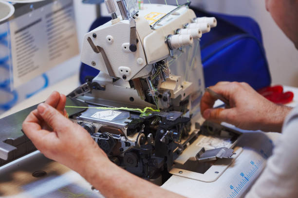Sewing machine and overlock repairing process, masters hands, tools, details Sewing machine and overlock repairing process, masters hands, tools, details sewing machine stock pictures, royalty-free photos & images