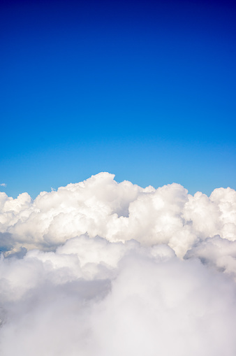 Deep blue sky above fluffy white clouds.