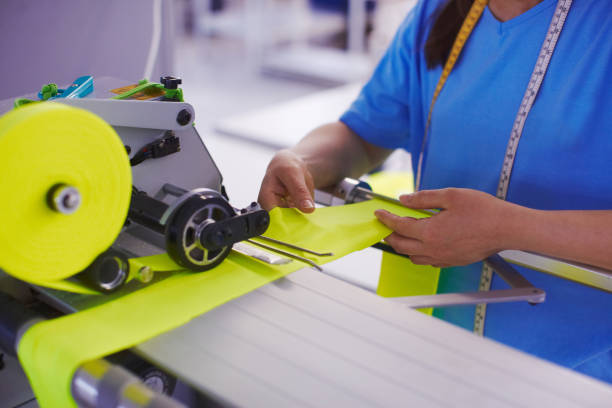 istock The worker at the factory cuts the fabric with scissors and with cutting machine 939081690