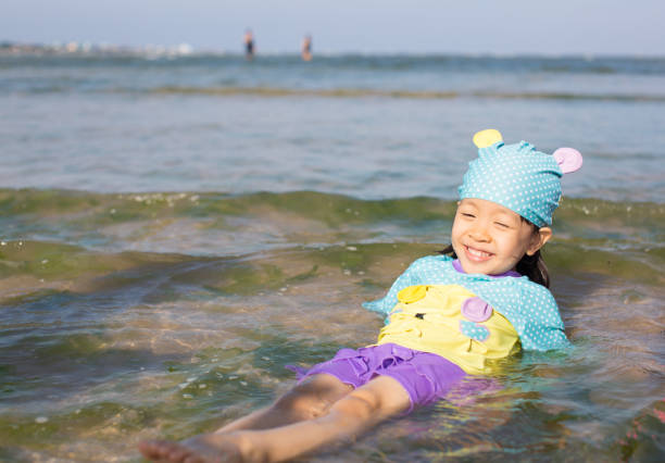 Child with Legs Stretched in Beach Water