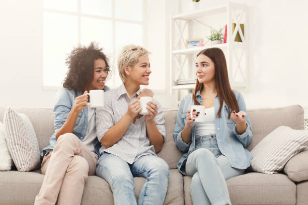 istock Three young female friends with coffee chatting at home 939084488