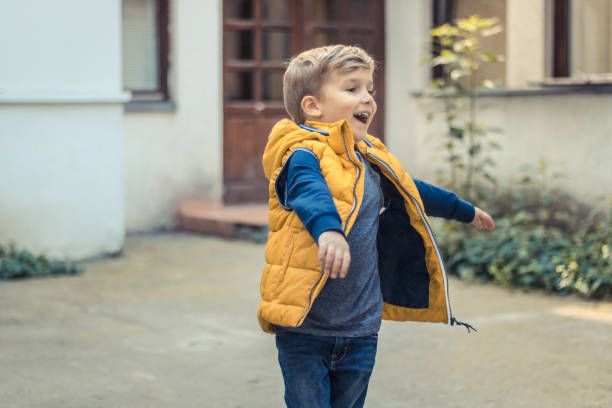 istock Carefree boy spinning with arms outstretched. 939084650